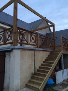 Finition avec garde-corps en bois classe IV profil Croix de Saint André et voile d'ombrage amovible sur poulie, lames de terrasse sur lambourdes en Pin Rouge classe IV, habillage de l'escalier avec balustre bois Poncé sur Loir Sarthe 72 Pergola Vivre Eco